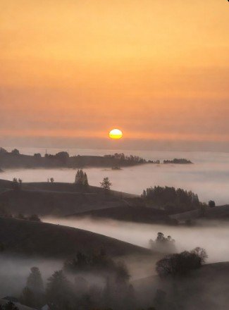 Sunrise over foggy hills landscape photo