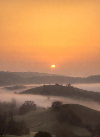 Sunrise over foggy hills landscape photo