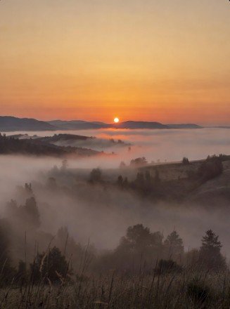 Sunrise over foggy hills landscape photo