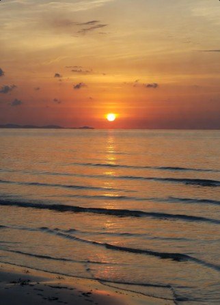 Tranquil beach sunrise with calm waves