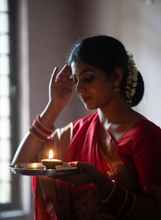 Woman doing morning puja with diya1