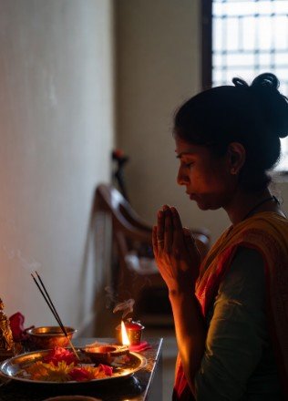 Woman doing morning puja with diya2